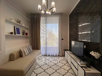 Stylish living room with modern decor, elegant chandelier, and large window view.