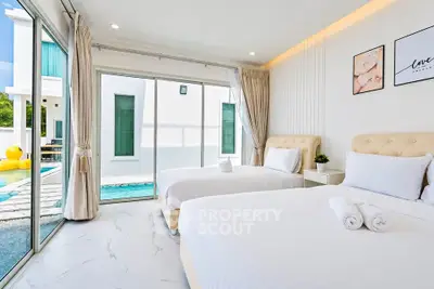 Luxurious bedroom with pool view, modern decor, and ample natural light in a contemporary home.