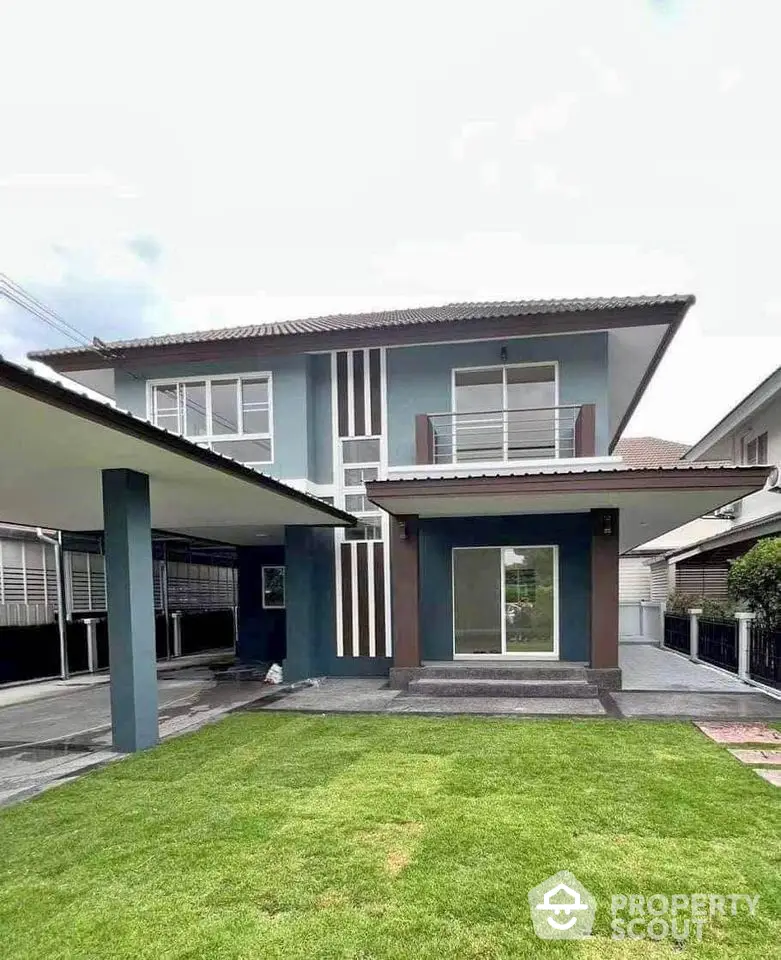 Modern two-story house with sleek design and spacious front lawn, perfect for family living.