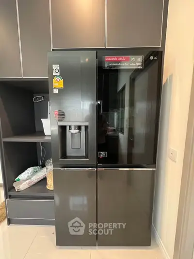 Modern kitchen with sleek black refrigerator and stylish cabinetry.