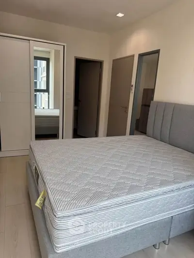 Modern bedroom with stylish bed and mirrored wardrobe in a cozy apartment.