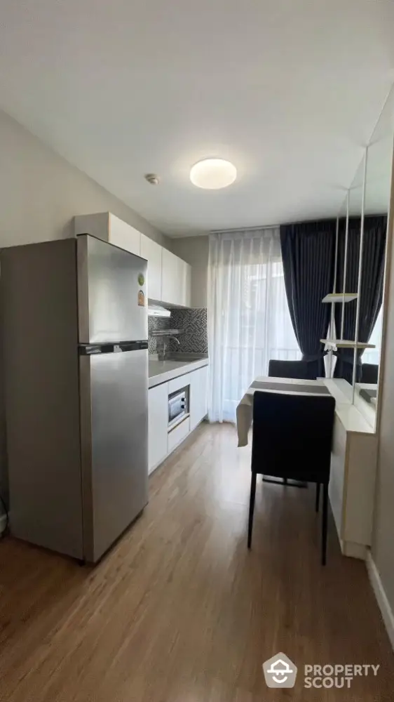 Modern kitchen with sleek appliances and dining area in a stylish apartment