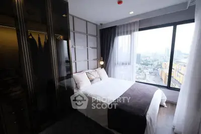 Modern bedroom with large window offering city view, featuring sleek wardrobe and cozy bedding.