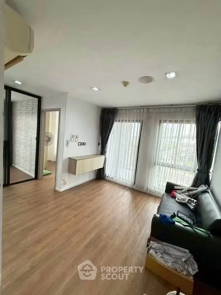 Spacious living room with large windows and modern decor in a stylish apartment.