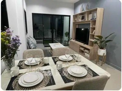 Stylish living room with dining area, modern decor, and balcony access in a cozy apartment.