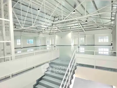 Spacious industrial-style interior with high ceilings and modern design