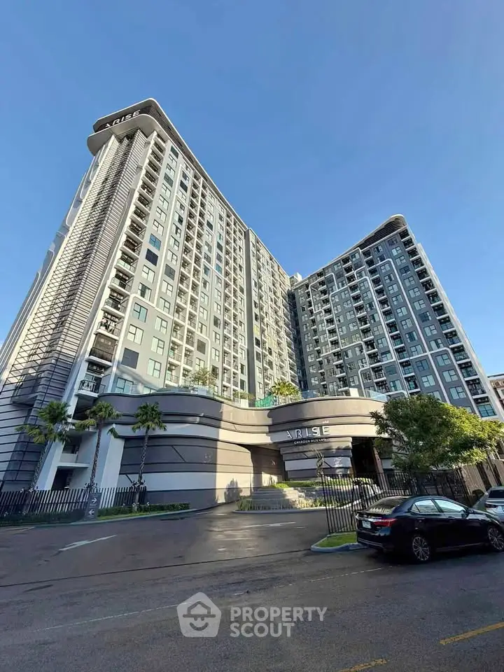 Modern high-rise residential building with sleek design and spacious balconies in urban setting.