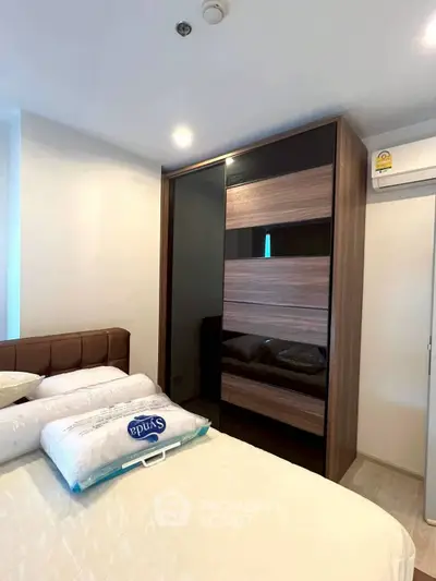 Modern bedroom with sleek wardrobe and cozy bed in a stylish apartment.