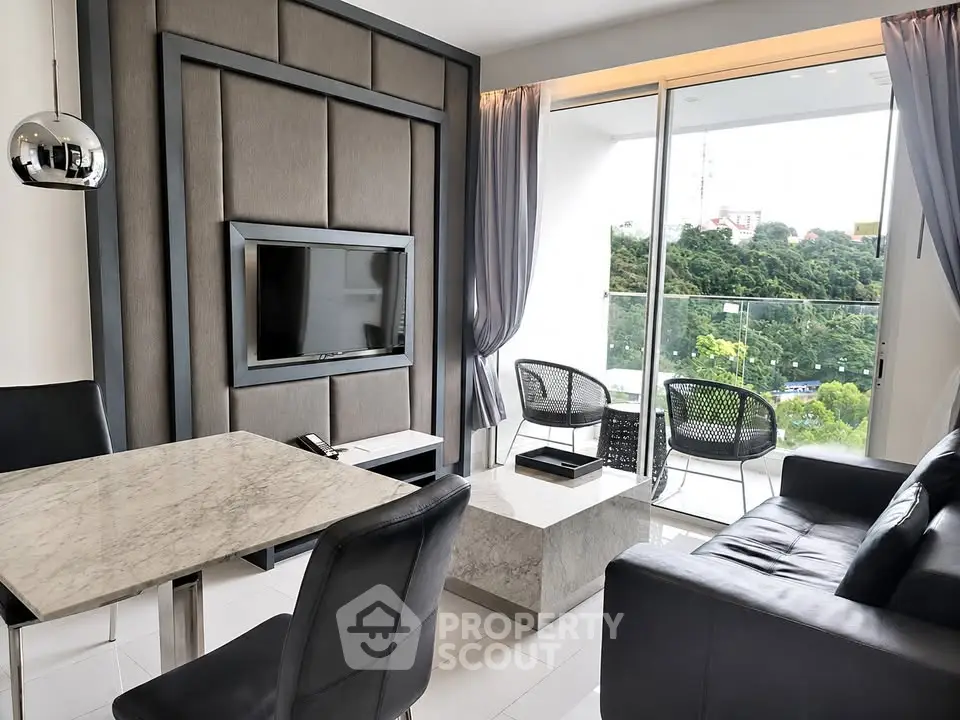 Modern living room with sleek furniture and large balcony offering scenic views.