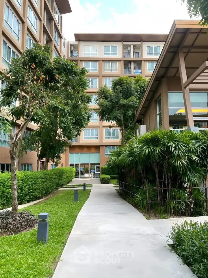 Modern apartment building with lush greenery and pathway