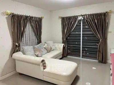 Cozy living room with elegant curtains and a plush white sofa, perfect for relaxation.