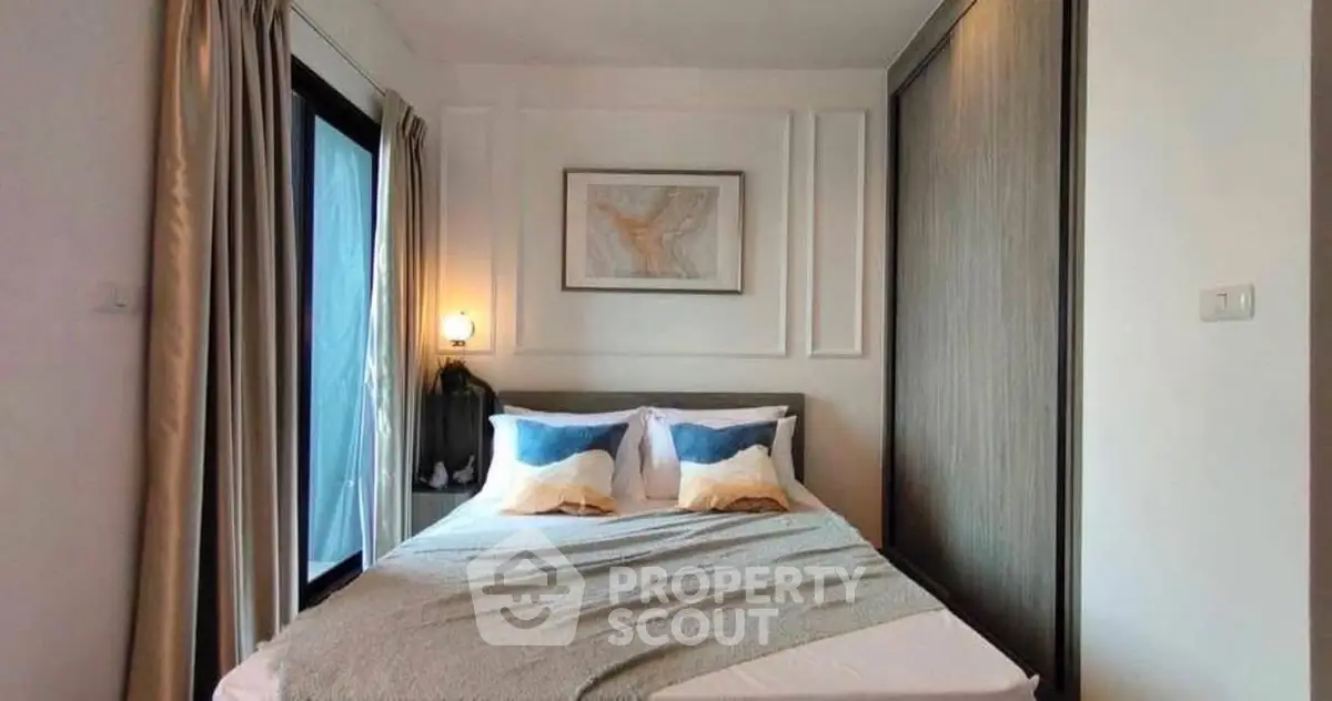 Cozy bedroom with modern decor and large window for natural light