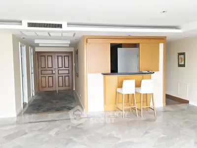 Spacious open-plan living area with modern bar counter and elegant flooring