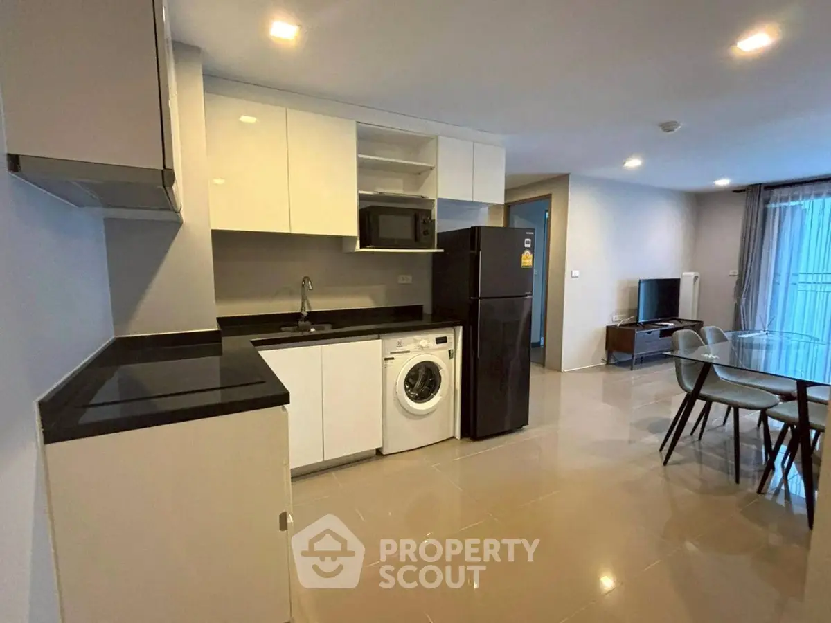 Modern open-layout kitchen with sleek appliances and dining area in stylish apartment