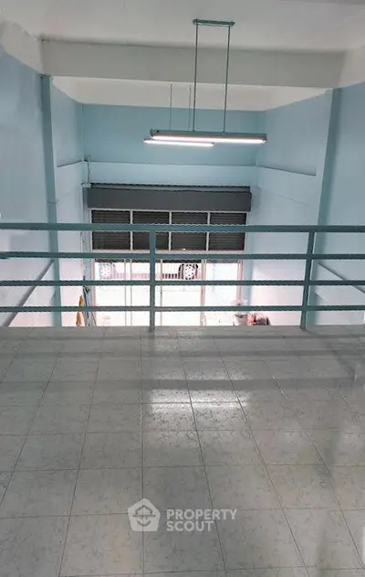 Spacious industrial-style loft with high ceilings and large windows, perfect for creative workspace or studio.