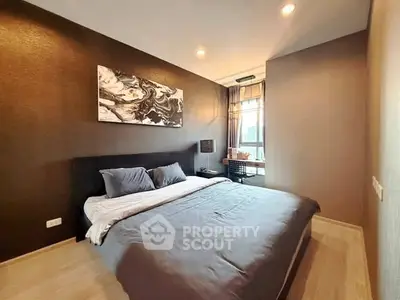 Modern bedroom with stylish decor and large window offering natural light.