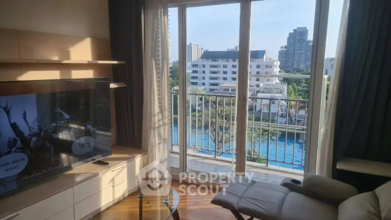 Spacious living room with balcony offering stunning city and pool views