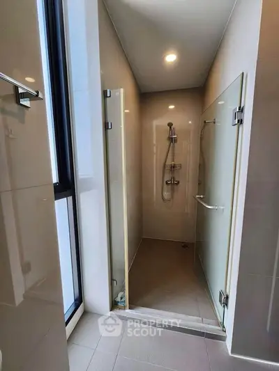 Modern bathroom with sleek glass shower enclosure and contemporary fixtures.