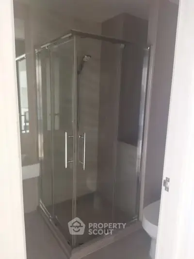 Modern bathroom with sleek glass shower enclosure and contemporary design.
