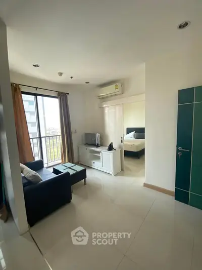 Modern apartment living room with natural light and city view, featuring cozy seating and sleek design.