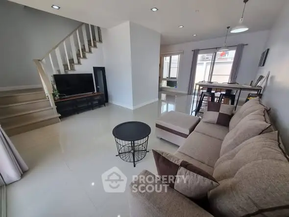 Spacious modern living room with elegant staircase and cozy seating area