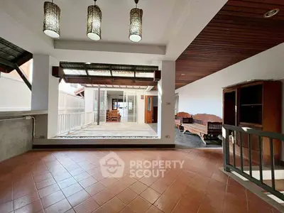 Spacious open-plan living area with elegant lighting and tiled flooring, perfect for modern living.