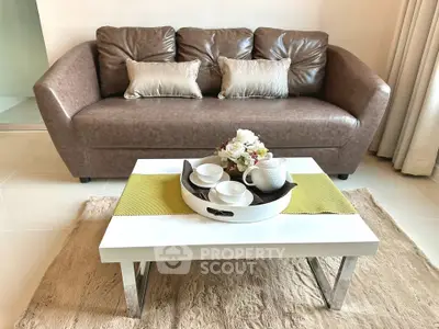 Stylish living room with modern brown sofa and elegant coffee table setup.