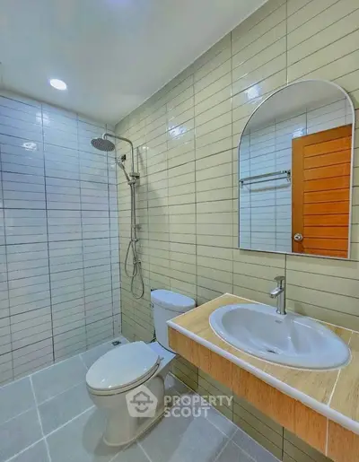 Modern bathroom with sleek tiles, shower, and stylish sink in a contemporary home.