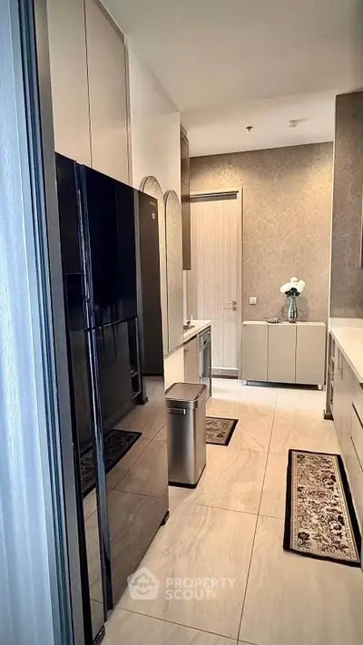 Modern kitchen with sleek black fridge and elegant decor