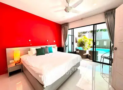 Spacious bedroom with pool view and vibrant red accent wall