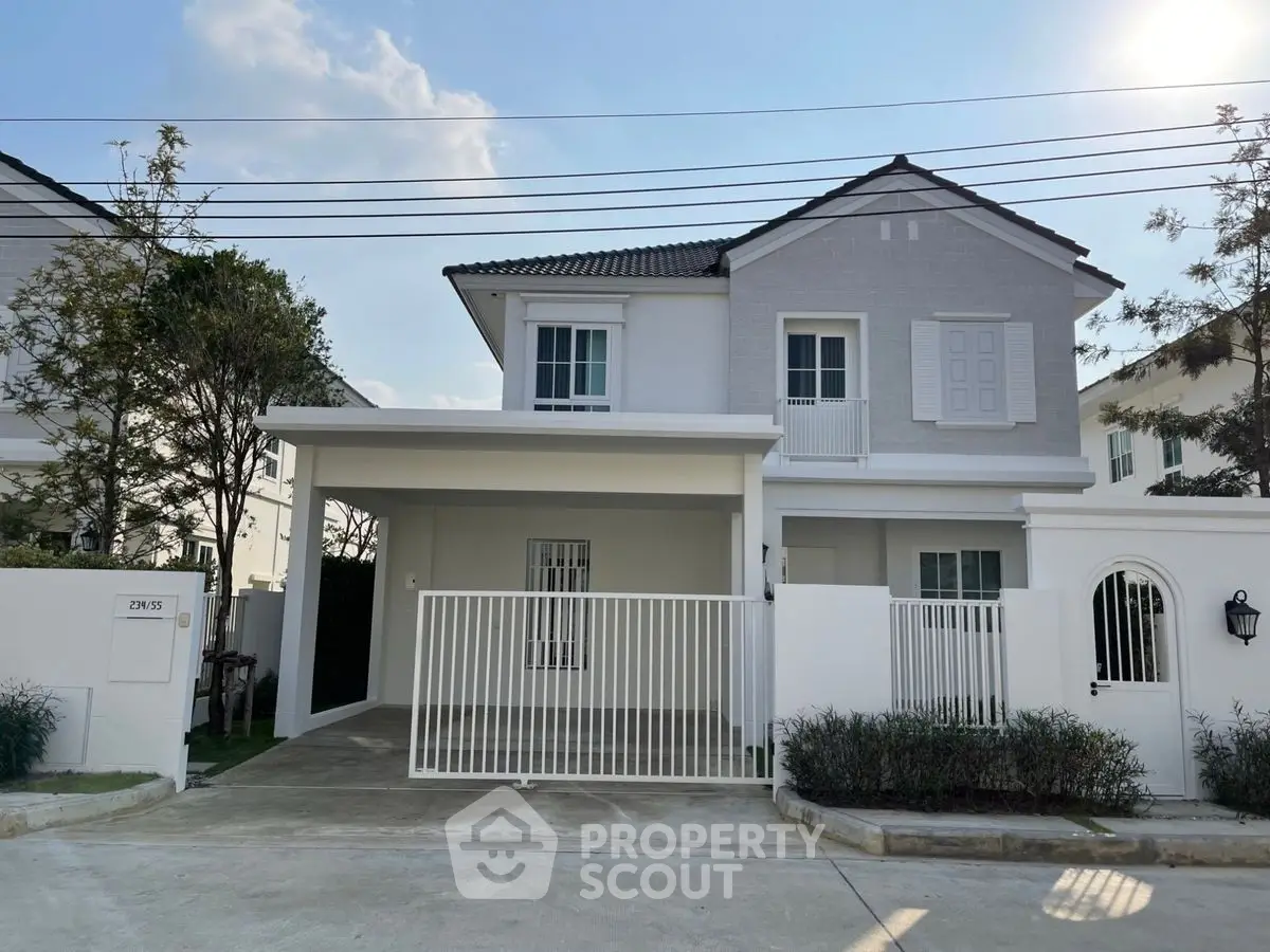 Charming two-story house with modern facade and gated driveway in a serene neighborhood.