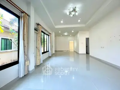 Spacious empty living room with large windows and elegant lighting