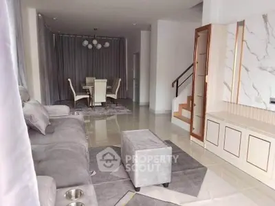 Modern living room with elegant dining area and stylish staircase