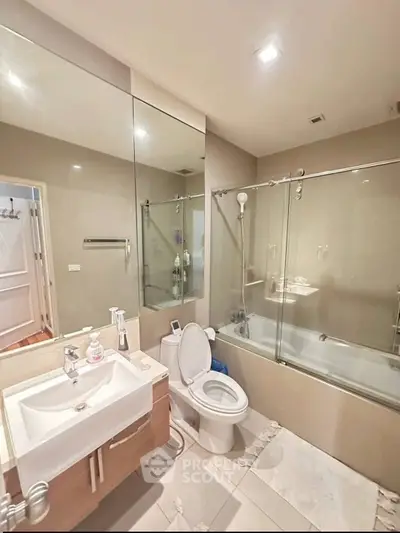 Modern bathroom with glass shower, sleek vanity, and neutral tones for a stylish and functional space.