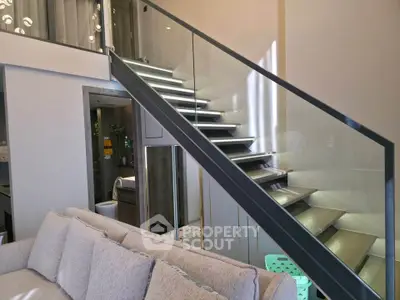 Modern duplex interior with sleek staircase and cozy living area