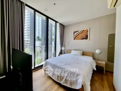 Modern bedroom with large windows and city view, featuring stylish decor and natural light.