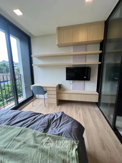 Modern bedroom with large windows and stylish furniture, offering a serene view and ample natural light.