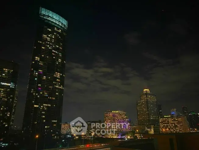 Stunning night view of city skyline with illuminated skyscrapers and vibrant lights.