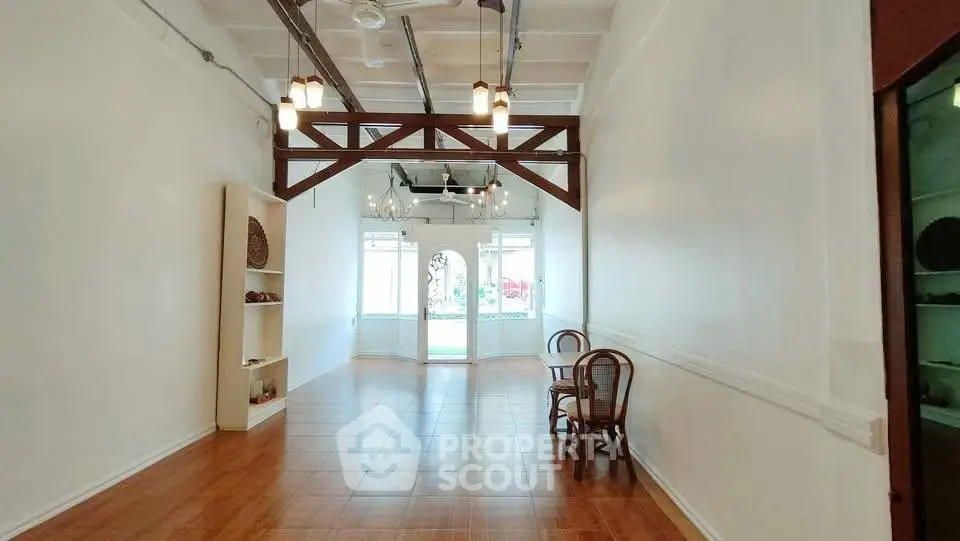 Spacious open-plan living area with wooden flooring and natural light.