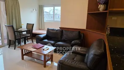 Cozy living room with leather sofa and dining area in modern apartment
