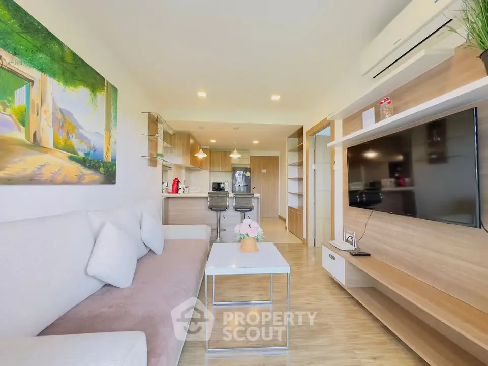 Modern living room with open kitchen, stylish decor, and natural light