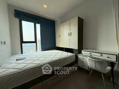 Modern bedroom with city view, featuring built-in wardrobe and stylish desk.