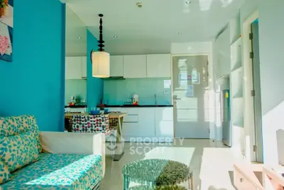 Bright modern living room with open kitchen layout and vibrant blue accents