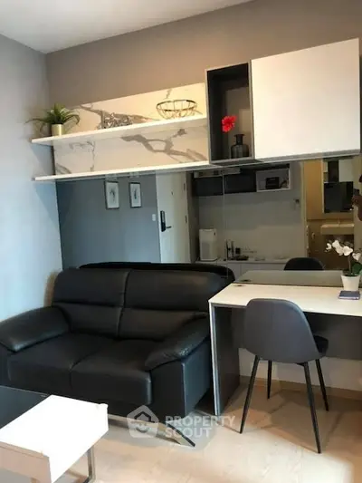 Modern living room with sleek black sofa and stylish desk setup