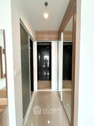 Modern hallway with sleek design and mirrored closet doors in a contemporary apartment.