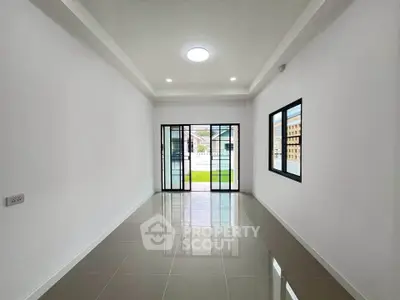 Spacious modern living room with large windows and sleek tile flooring