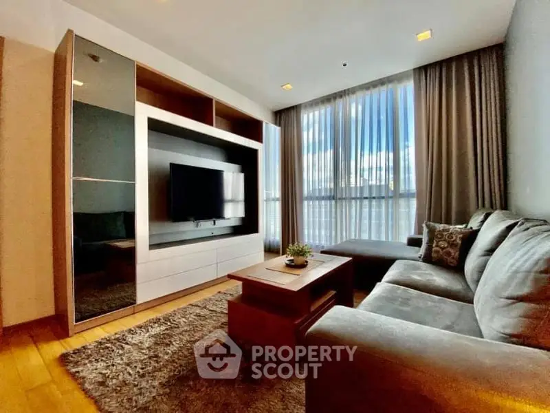 Modern living room with cozy sofa, large window, and stylish decor
