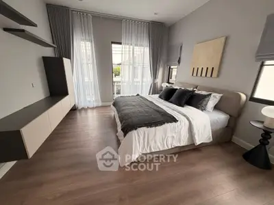 Elegant bedroom with modern decor and large windows offering natural light