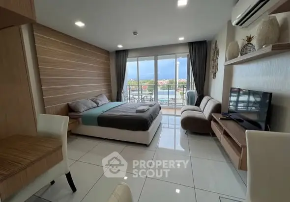 Modern bedroom with balcony and scenic view, featuring stylish decor and natural light.