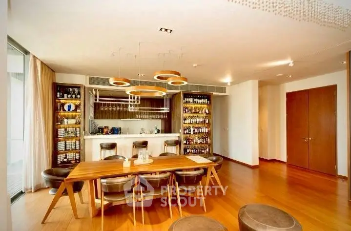 Luxurious dining area with elegant wooden table and stylish bar setup, perfect for entertaining guests.